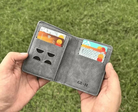 Pak wallets grey leather M-Wallet with multiple card slots held in hands against a green grass background