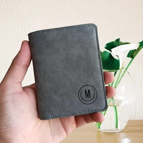 Pak wallets grey leather M-wallet with embossed initial logo held in hand